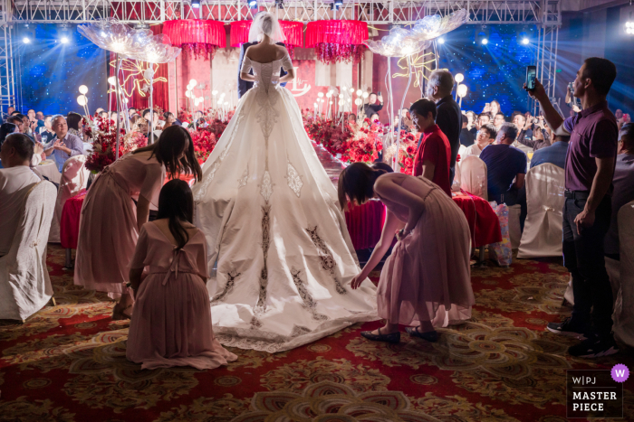 China wedding photo from the Hotel Wedding ceremony of the bride getting help with her long dress train China wedding photo from the Hotel Wedding ceremony of the bride getting help with her long dress train