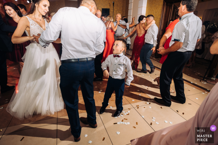 El niño intenta pedirle a la novia que baile en el Hotel Corona Palace, Leznica Wielka, Polonia