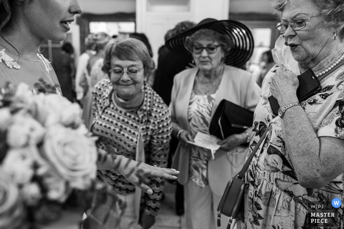 Bride is showing her wedding ring to some ladies at Domaine du Chateau de la Rive