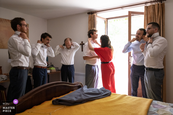 The groom with his groomsmen all put on their ties in preparation for the wedding ceremony