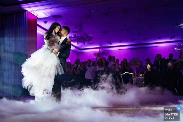 Fotografía de boda de Sofía, Bulgaria del Primer baile con niebla y luces púrpuras