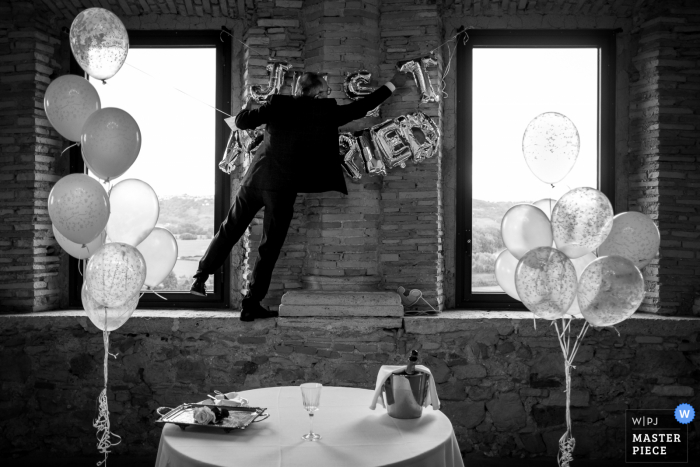 A guest is mounting the "just married" writing before cake cutting in Italy A guest is mounting the "just married" writing before cake cutting in Italy