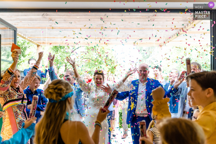 La novia y el novio reciben una celebración de confeti en esta boda en el patio trasero de Hengelo