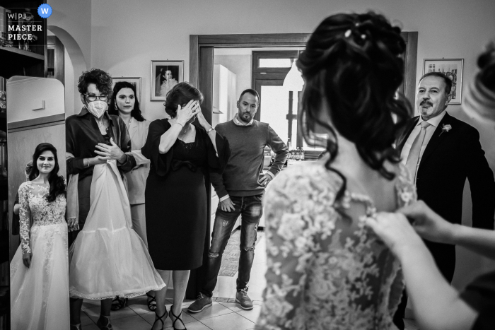 Mother of the Bride and guests facing just dressed Bride in Italy