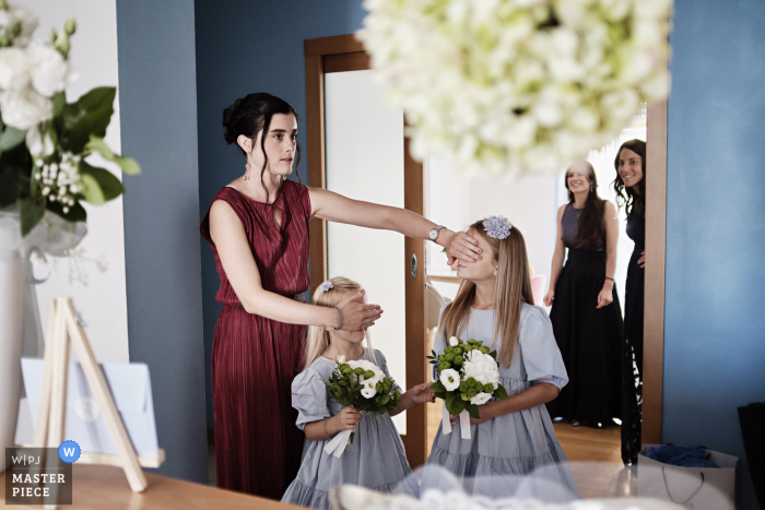 The flowergirls eyes are covered at the bride is dressing in Milano, Italy The flowergirls eyes are covered at the bride is dressing in Milano, Italy