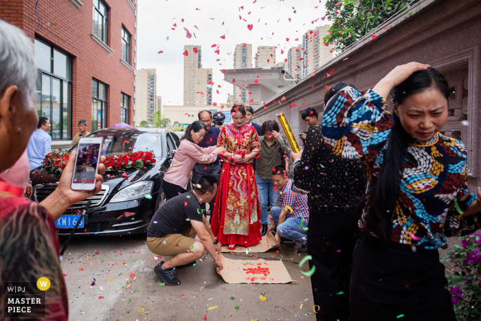 Image de mariage chinois: dans les coutumes de mariage locales, la mariée doit marcher sur le tissu par terre pour entrer par la porte du marié