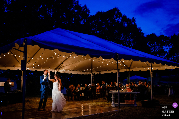 Ein erster Tanz während der blauen Stunde für ihre Hochzeit auf einem Hügel in Asheville, NC