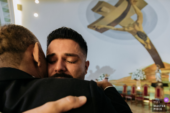 The thrilled groom embraces his father at the Catedral de Sao Carlos Borromeu on his wedding day