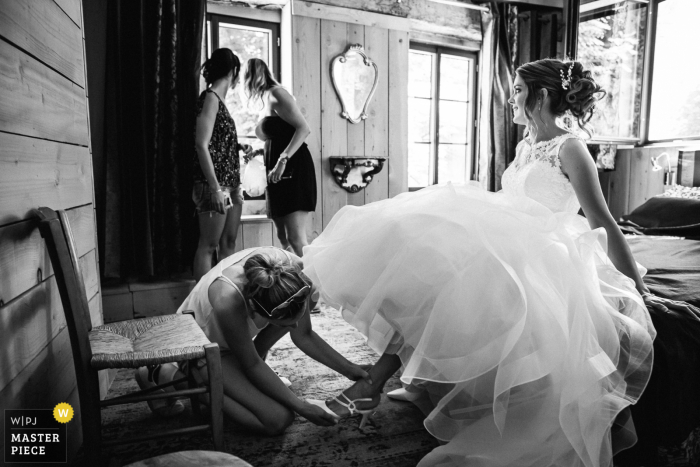 Getting the bride ready, her friends see the groom arriving outside in France Getting the bride ready, her friends see the groom arriving outside in France