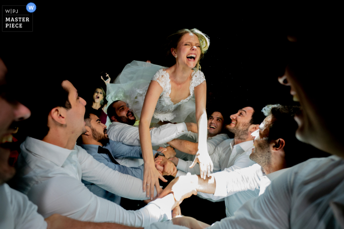 Bride jumps into the arms of men to catch her during her reception at the Allegro Buffet 