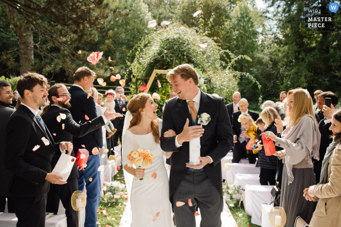 La novia y el novio dejando la ceremonia en el Schloss Amerang en Baviera, Alemania