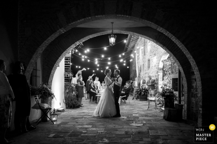 Los novios enmarcados en un arco en el Castello di Buttrio mientras tienen su primer baile