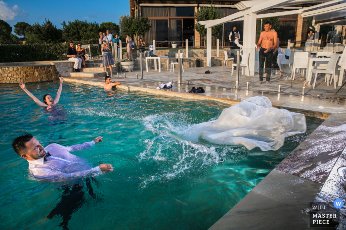 Hochzeitsfoto von Serra De 'Conti zeigt die Braut, die Spaß im Wasser des Pools hat