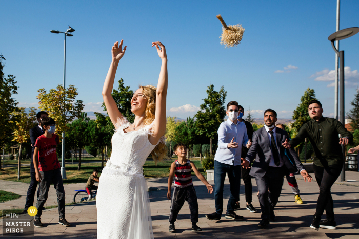 La sposa di Istanbul lancia il suo bouquet a un gruppo di uomini, poiché non c'erano donne single a catturare i fiori