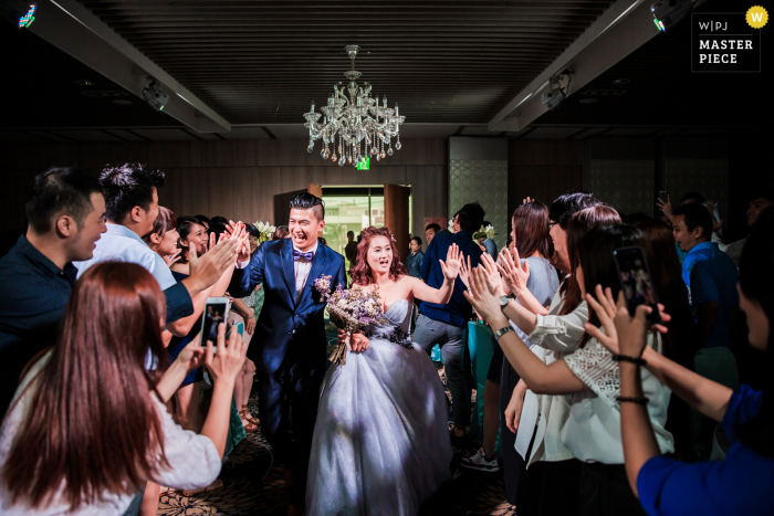 The newlyweds walked into the wedding venue and gave high fives to congratulate each other one by one at the wedding banquet in Taiwan