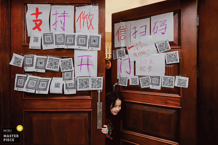 Imagem de casamento chinês de uma menina espiando pela porta, coberta por mensagens