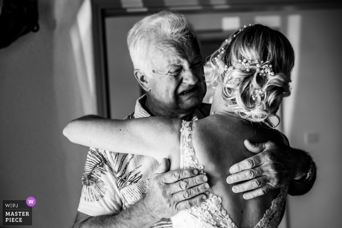 French bride hugs her emotional father on one of the biggest days of her life