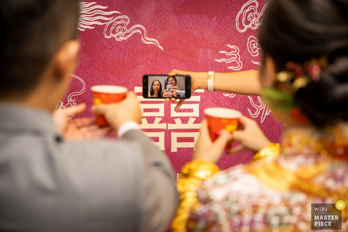 Imagen de boda de Guangdong de un momento de tomar el té con la familia en Australia a través de un teléfono móvil