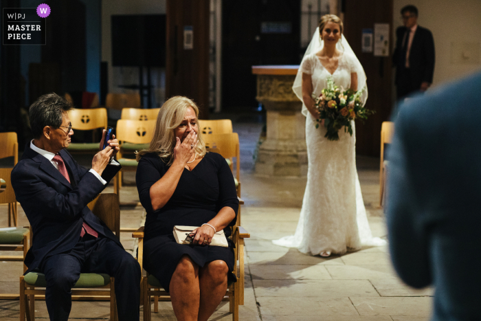 moeder van de bruid huilt als de bruid naar de ceremonie in Streatham Church loopt