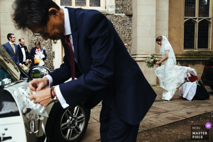 Huwelijksfotografie in Engeland van buiten de Streatham-kerk van de bruidsauto die wordt versierd