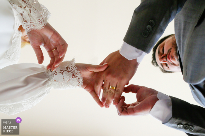 Alegranza Eventos wedding image of the groom placing a ring on the bride's finger