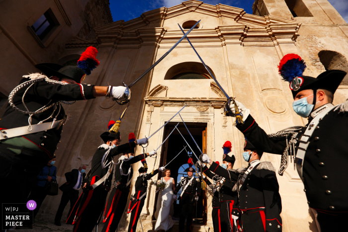 Fotografía de boda de Castello Carafa di Roccella Jonica, Italia del Cuerpo de Arma de los Carabinieri, Piquete de Honor durante la salida de los cónyuges