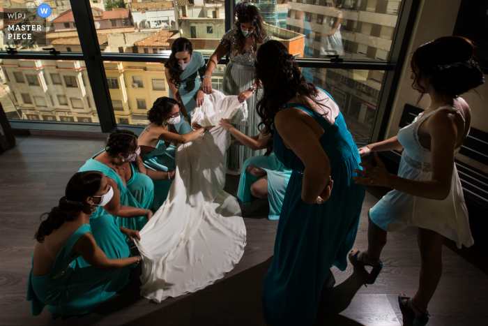 Moment des Brautkleides mit dem Hochzeitsfoto der Brautjungfern von der Braut, die sich in Toledo fertig macht