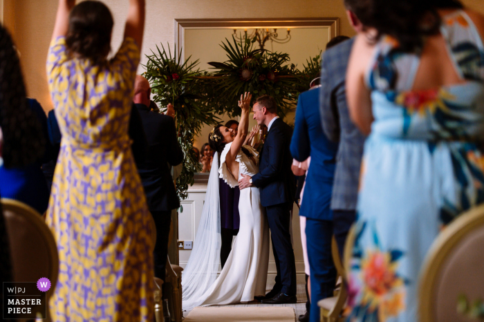 Fotografia de casamento de Faithlegg, Irlanda, da noiva e do noivo celebrando a cerimônia de casamento