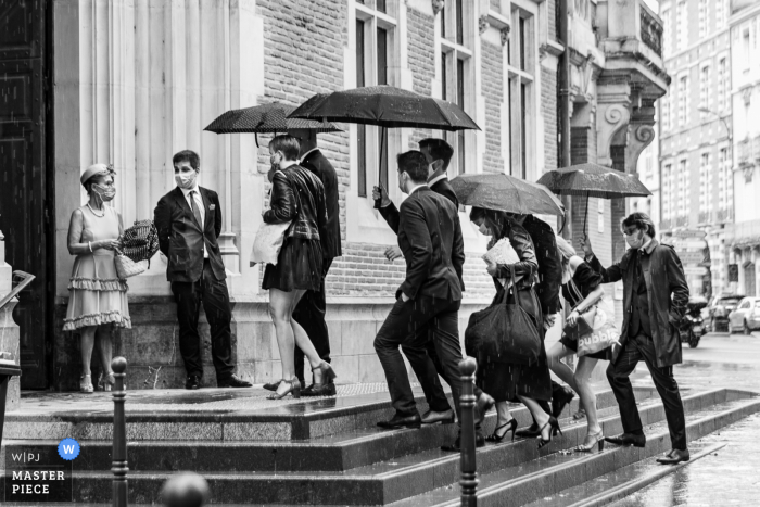 Invitado entrando a la iglesia en Toulouse, Francia, mientras está lloviendo