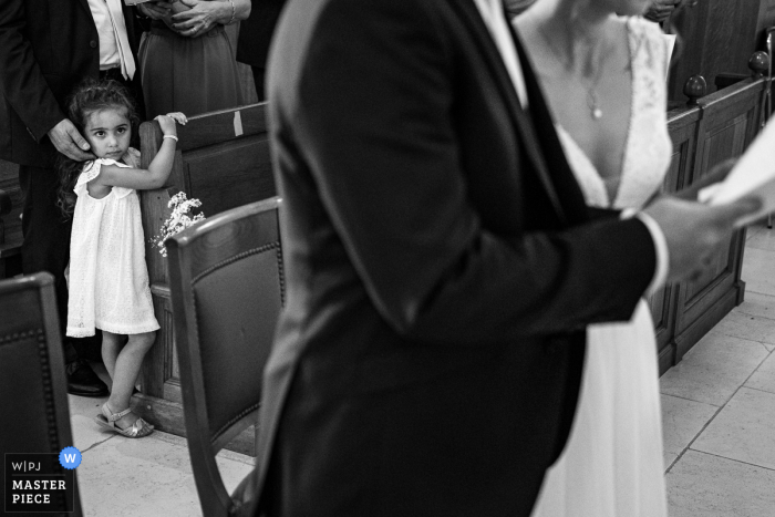 Hochzeitsfotografie von einer Zeremonie in Rembouillet Frankreich, Kirche mit einem Mädchen, das zuschaut und ein wenig verwirrt und verängstigt ist