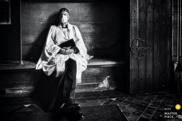 Huwelijksfoto van The St Oswalds Church, Oswestry, Britse dominee die wacht tot de bruid arriveert voor haar ceremonie - Ze was meer dan een beetje laat