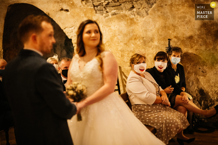 Huwelijksfoto van Neidpath Castle, Peebles, Schotland Gasten die tijdens de ceremonie hun COVID-maskers dragen