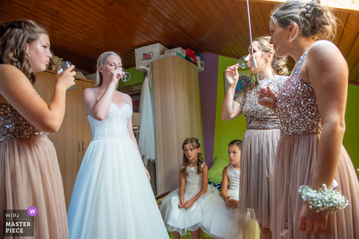 Prekmurje, Slovenië Meisjes hebben een leuke tijd met een drankje op deze trouwfoto voor de ceremonie