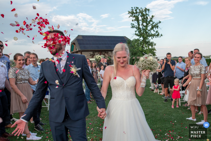 Panonska vas, Tešanovci, Slovenia wedding photo of a Lucky moment with flying flower petals Panonska vas, Tešanovci, Slovenia wedding photo of a Lucky moment