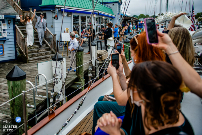 Der Hochzeitsfotograf aus Maryland fängt dieses Bild von Braut und Bräutigam ein, die ihre Gäste auf einem Schiff für eine Cocktailstunde treffen