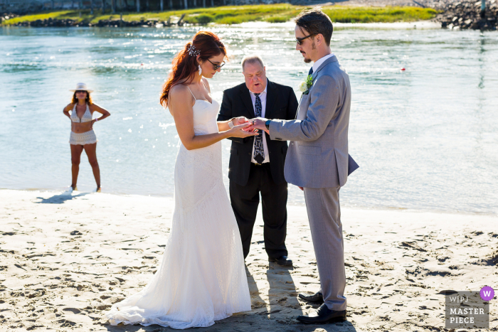 Exchanging rings at your beachside elopement ceremony on a holiday weekend means unexpected guests will be cheering you on from afar in bathing suits at Ogunquit, Maine Exchanging rings at your beachside elopement ceremony on a holiday weekend means unexpected guests will be cheering you on from afar in bathing suits at Ogunquit, Maine