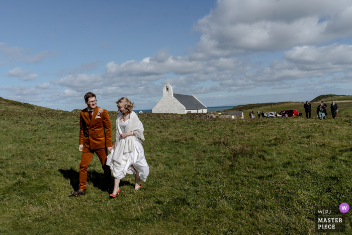 Gli sposi aprono la strada dopo la loro cerimonia di matrimonio in questa chiesa in cima a una scogliera nel Galles occidentale presso la chiesa di Mwnt