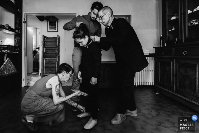 Oradour-sur-Glane wedding picture of a kid getting ready, attended to by three adults