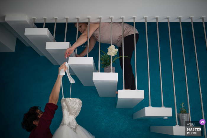 Siracusa preparándose la fotografía de la boda del vestido de las novias colgando de las escaleras en el interior