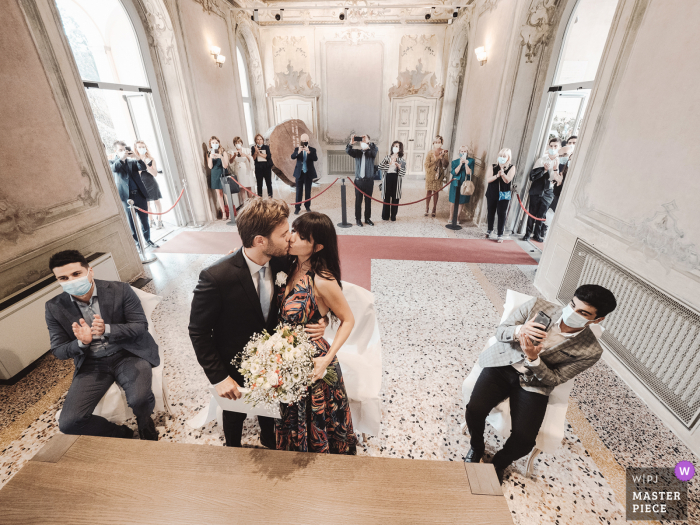 Imagem da cerimônia de casamento na Villa Litta Modigliani do noivo beijando a noiva