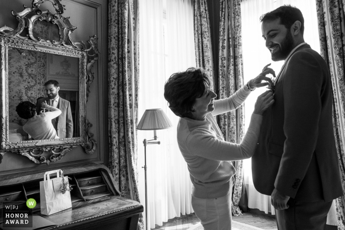 Fotografia de casamento do Avignon Hotel la Mirande do noivo se preparando com ajudante de flores