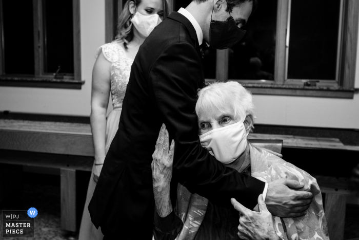 Photo by: <a href="https://www.wpja.com/contests/2020-v04/best-wedding-photographers/2602905">David Clumpner - Missoula Montana</a> Montana wedding photographer shooting images in Darby of a grandma hugging grandson with masks on