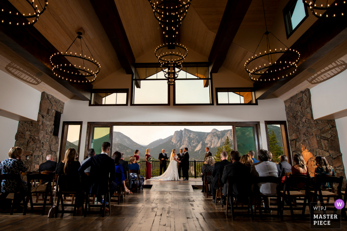 Fotografía de la boda de Black Canyon Inn Estes Park, CO con una toma amplia de la ceremonia de la boda en el interior