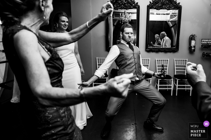 Foto di matrimonio in Colorado dalla Torre dell'orologio di Denver dello sposo che fa una faccia buffa mentre balla