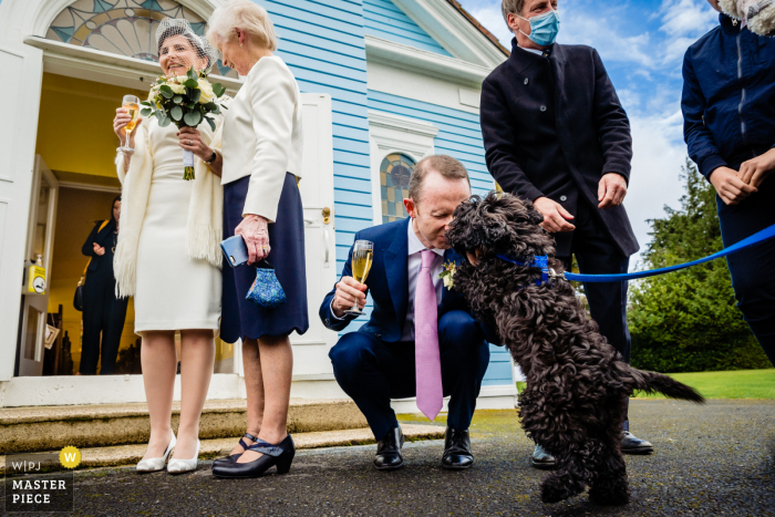 Un fotografo di matrimoni di Dublino ha creato questa immagine fuori dalla Kilternan Church, Dublino, Irlanda dello sposo che saluta il suo cane dopo la cerimonia