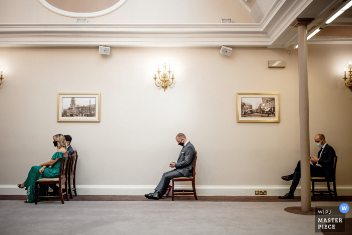 Photo by: <a href="https://www.wpja.com/contests/2020-v04/best-wedding-photographers/2603304">Steven Rooney - Banks Lancashire</a> UK wedding photography from the stockport town hall showing wedding guests in covid-19 face masks