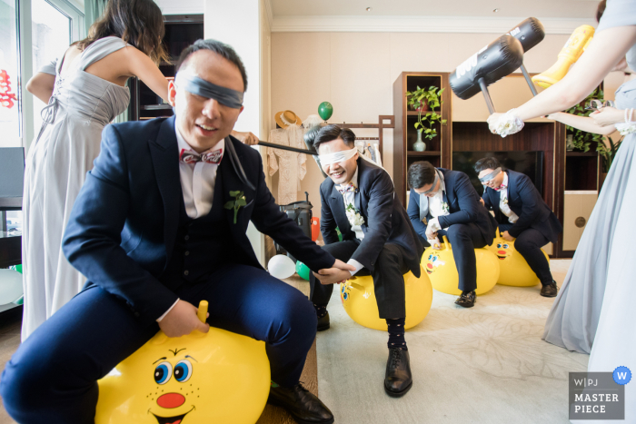 Fotografía de boda de Hangzhou, China, de los novios rompiendo la puerta y jugando el juego