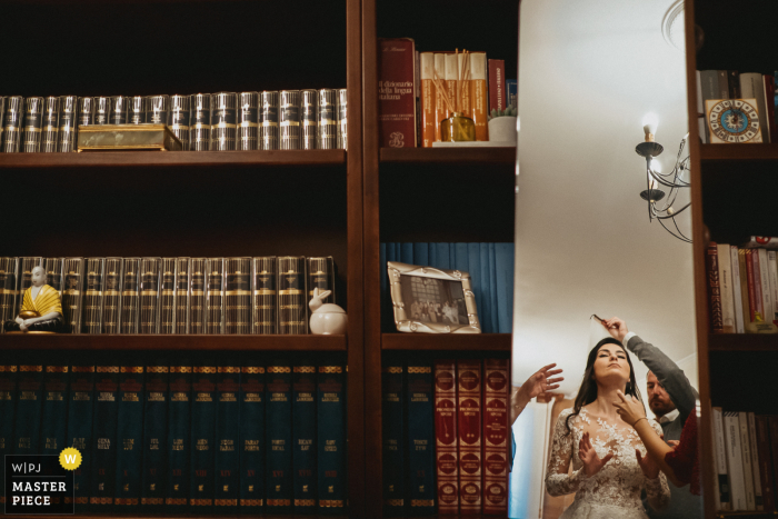 Fotografia di matrimonio Roma dalla casa della sposa laziale mentre la sposa si prepara a mettere il velo