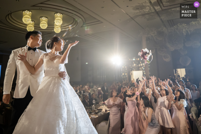 Un photographe de mariage londonien a pris cette image de lancer de fleurs au Sunee Grand Hotel, Ubon Ratchathani - Bouquet time