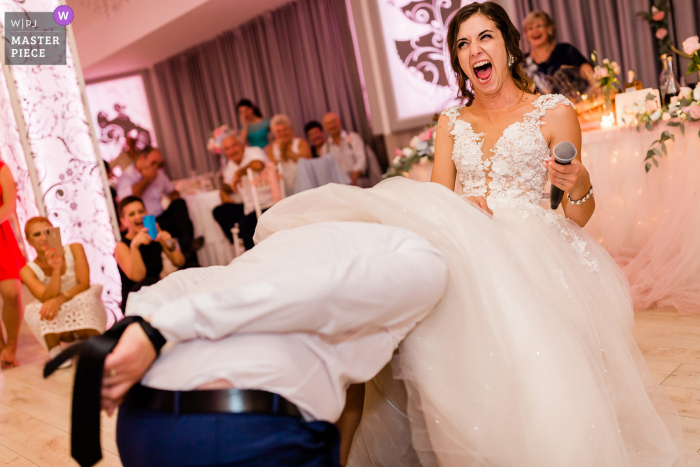 Fotografia di matrimonio a Sofia dal luogo del ricevimento Hotel Akord a Sofia, Bulgaria, che mostra lo sposo Alla ricerca di una giarrettiera